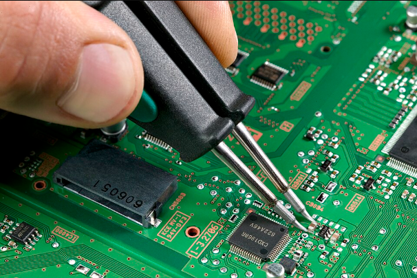 PCB 위에서 핀셋으로 SMD 부품을 납땜하는 근접 사진, 초록색 회로기판과 정밀 인두 팁이 보이는 모습